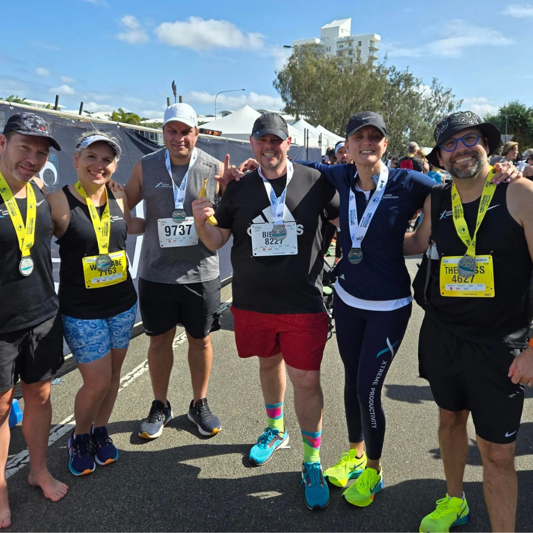 XP staff standing for a group photo, with medals on after the Sunshine Coast half marathon